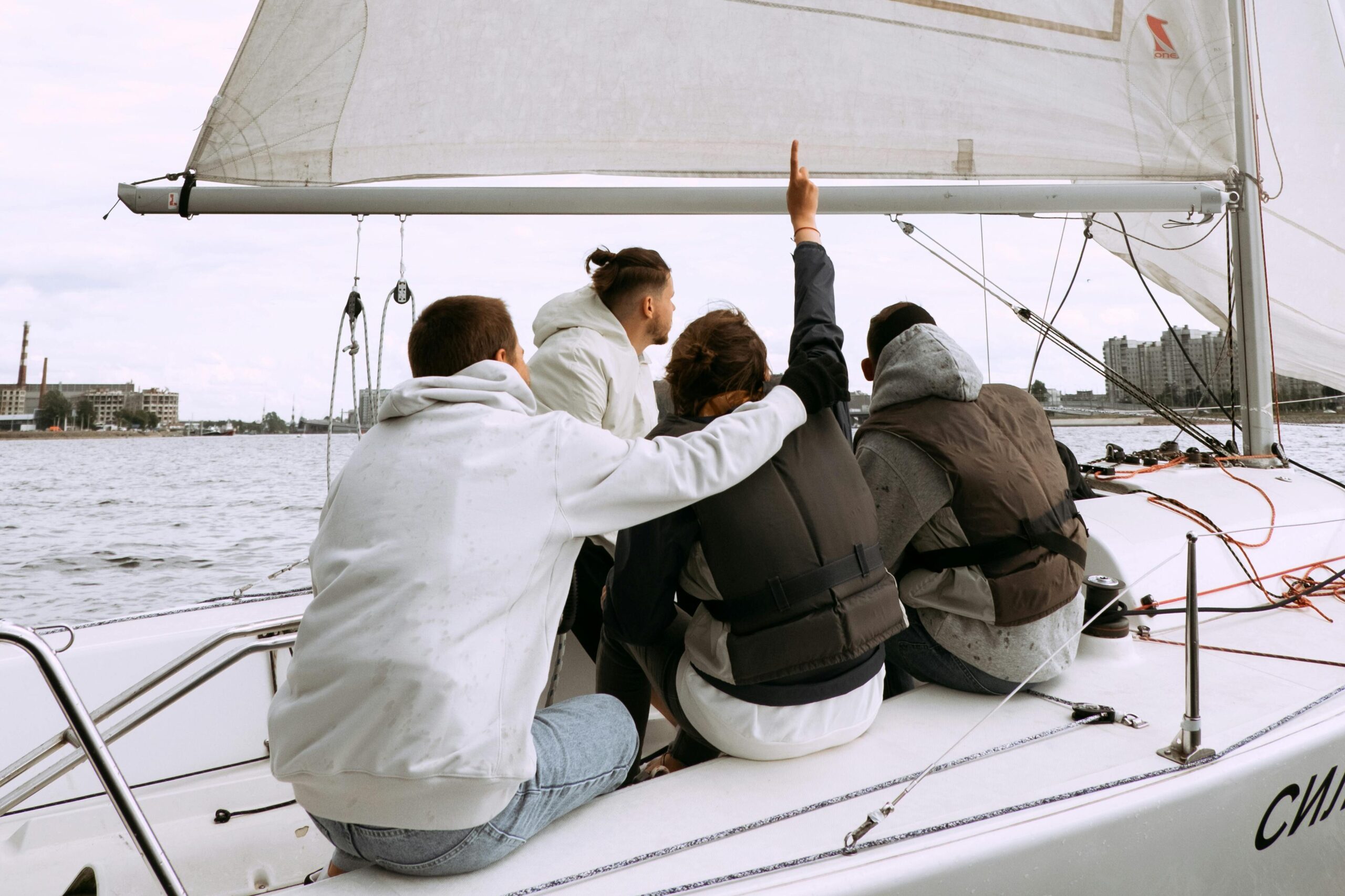 A group of friends enjoying a sailing trip on a yacht during overcast weather. Perfect for adventure and lifestyle themes.